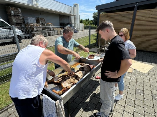 Mitarbeiter auf Bänken am Sommerfest 2022